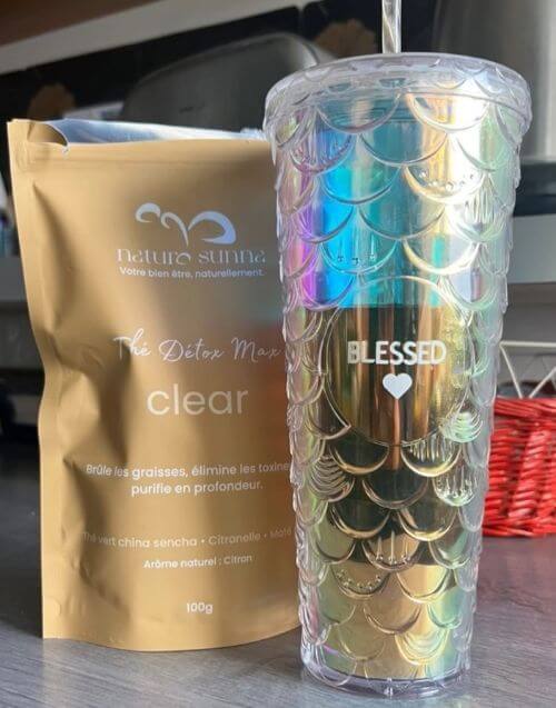 Photo client montrant le thé détox Clear de Naturo Sunna accompagné d’une boisson infusée, illustrant une utilisation réelle et simple du produit au quotidien
