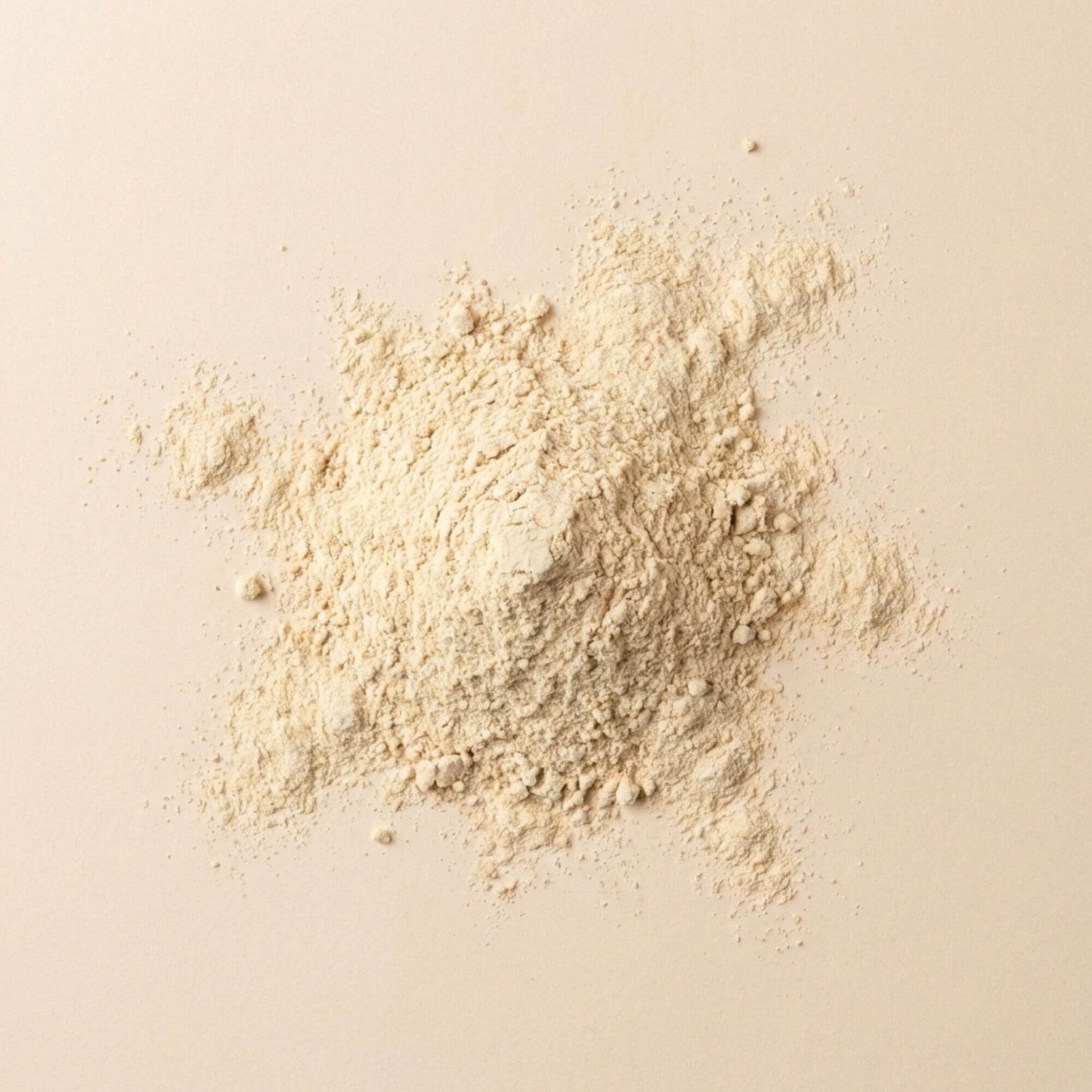 Pollen de palmier en poudre fine, présenté en tas sur fond beige neutre, matière brute non transformée.