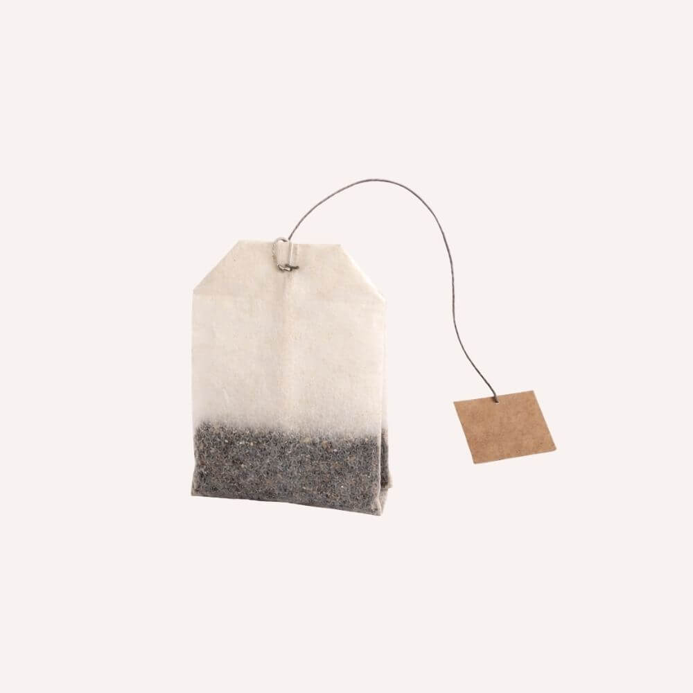Sachet d’infusion industrielle contenant des plantes broyées dans un filtre papier, illustrant un format standard d’infusion prête à l’emploi.